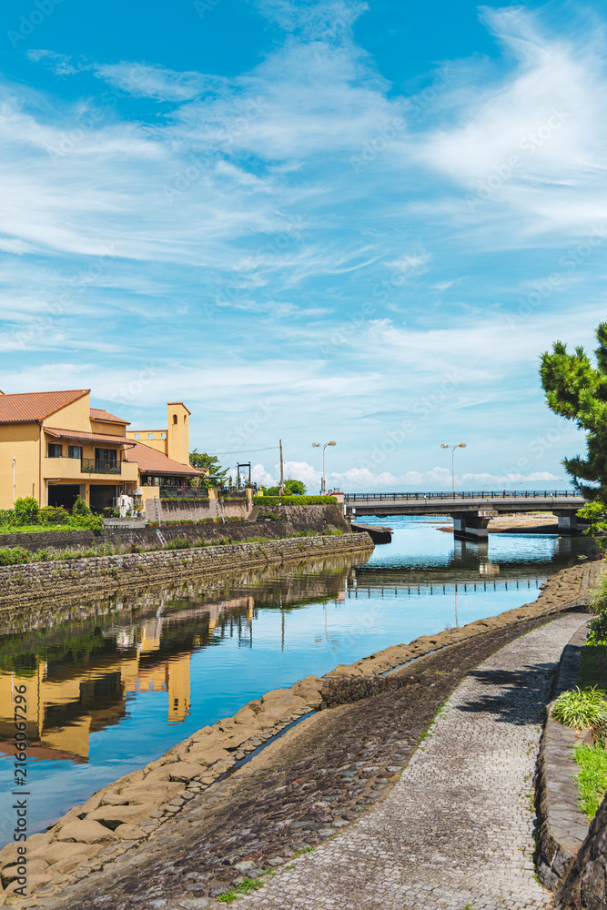 Fototapeta premium 伊豆の街を流れる川と橋が映る夏の青空の風景