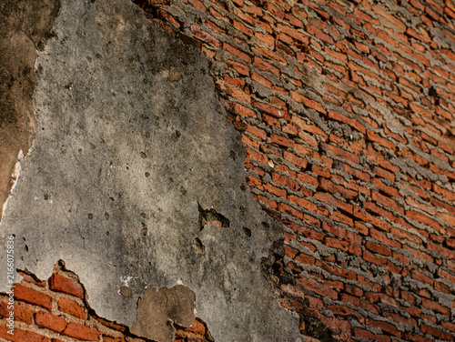 Bild auf Leinwand Cracked Plaster Wall Exposing Red Brick Underneath, Weathered Ruin Texture Backg