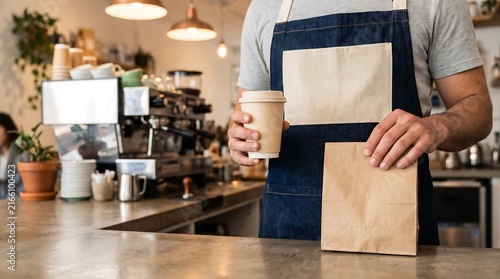 Barista Preparing Takeaway Coffee and Paper Bag Order in Modern Coffee Shop