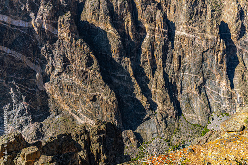 Bild auf Leinwand Sunlight and shadow reveal the ancient striated rock face of Black Canyon's steep walls