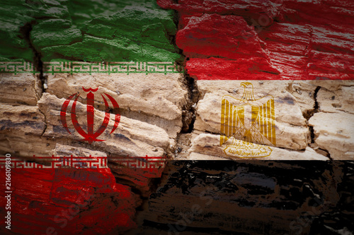 Iran and Egypt flags on cracked wood symbolizing political tension and conflict.