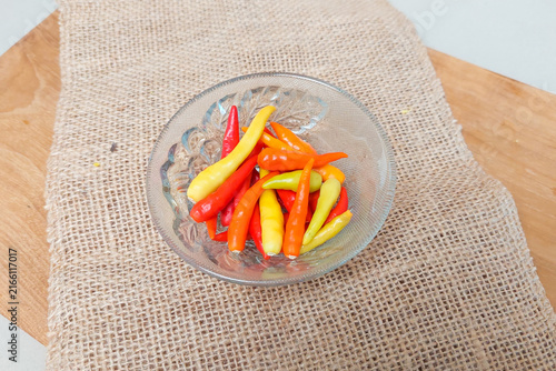 Konstfotografi Red and green chilies in a small glass bowl.