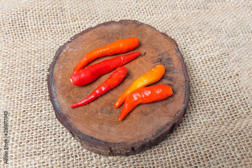 Fotografía Red chilies on a small wooden tray atop a burlap sack.