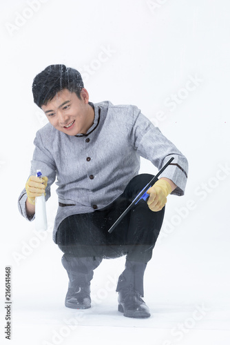 фотографія Young man cleaning glass with spray bottle and squeegee