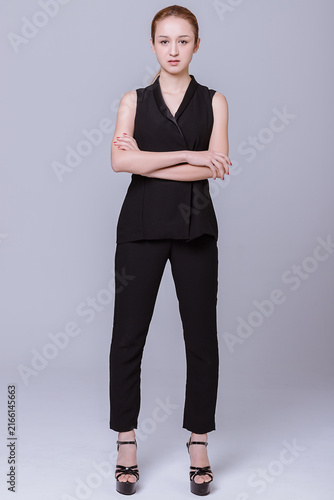 Full Body Portrait of Serious Young Woman in Black Outfit with Crossed Arms