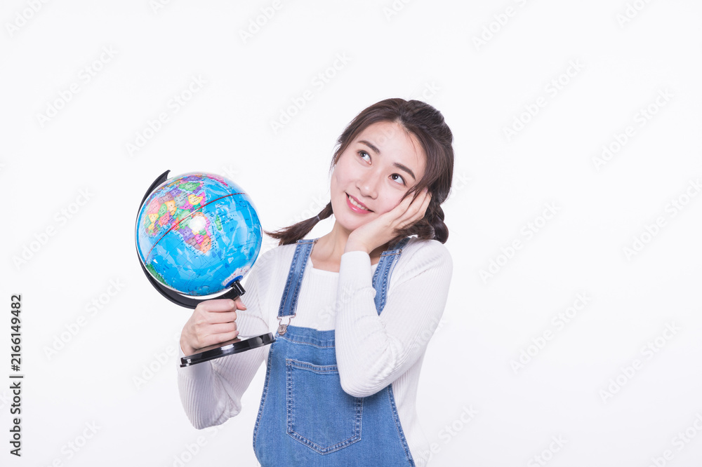 Fototapeta premium Thoughtful young woman holding a globe on white background