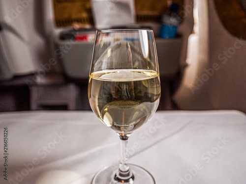 SINGAPORE - SEPTEMBER 26, 2012: Glass of white wine served in Business Class onboard an Emirates flight from Singapore to Brisbane, Australia