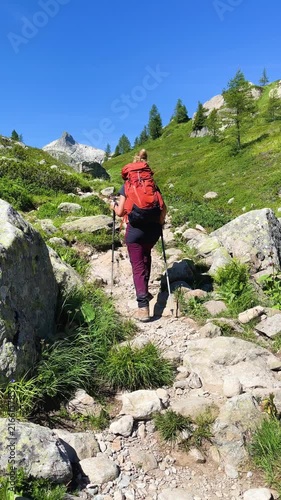 Woman Hiker with Backpack Walking on Rocky Mountain Trail, Adventure and Trekking Concept