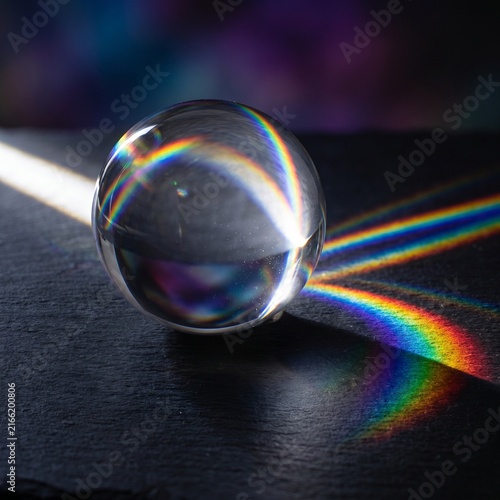 Crystal Sphere Refracting Rainbow Light Across Black Surface