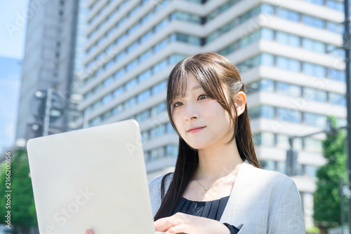 Naklejka ビル街でノートパソコンを使う日本人女性