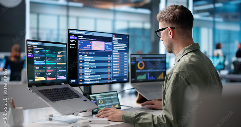 Naklejka premium Young Cybersecurity Analyst Uses Laptop