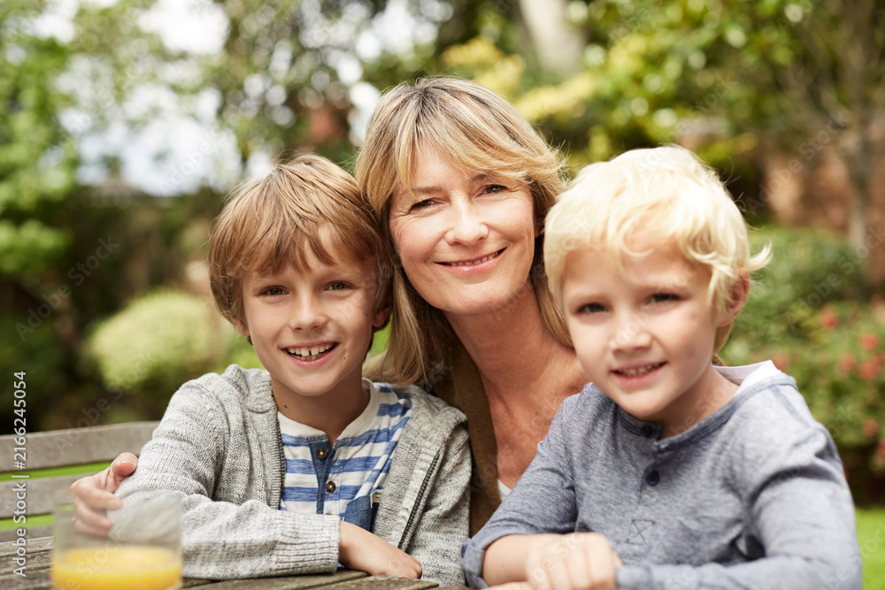 Fototapeta premium Portrait, grandmother and kids in nature with smile, love and bonding together on holiday. Happy, mature woman and children outdoor with embrace, affection and parental support on getaway vacation