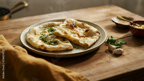 Freshly baked flatbread topped with herbs and olive oil on rustic wooden board