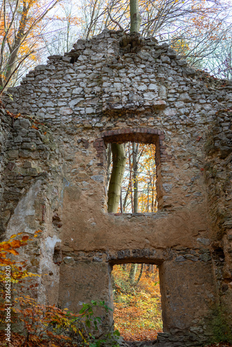 Weathered stone and brick gate ruins associated with the historic Carmelite complex near Devil’s Bridge in Czerna, Lesser Poland. Ancient masonry openings frame colorful autumn woodland in Eliaszówka 