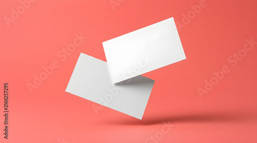 Mockup of two blank business cards floating on a vibrant coral background