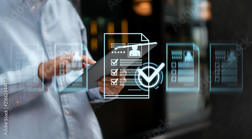 Business professional using tablet with digital checklist, verified documents, approval workflow and compliance management for office background.