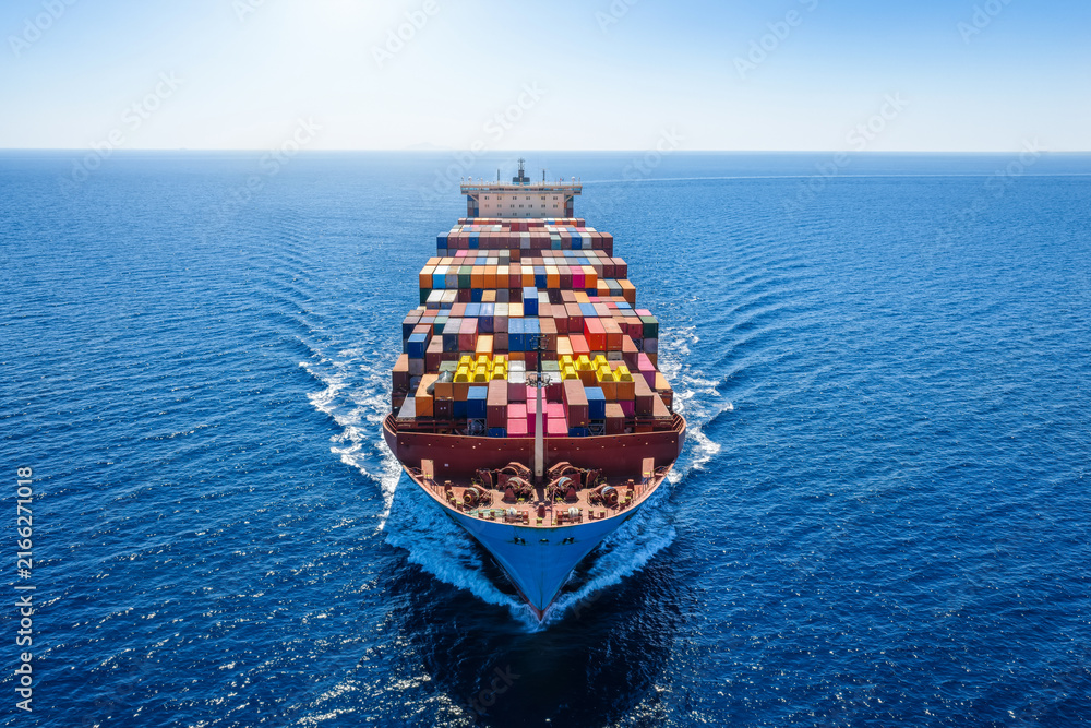 Obraz premium Aerial front view of a heavy loaded, large super cargo container ship sailing over the ocean
