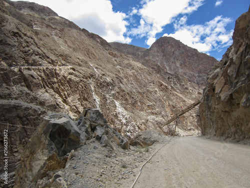 Foto Mountainous road with rocky cliffs under a blue sky