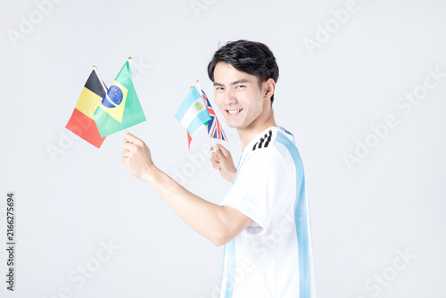 Smiling soccer fan holding Belgium, Brazil, Argentina and United Kingdom flags