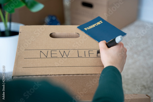 Obraz na płótnie Writing “New Life” on Moving Box with Passport
