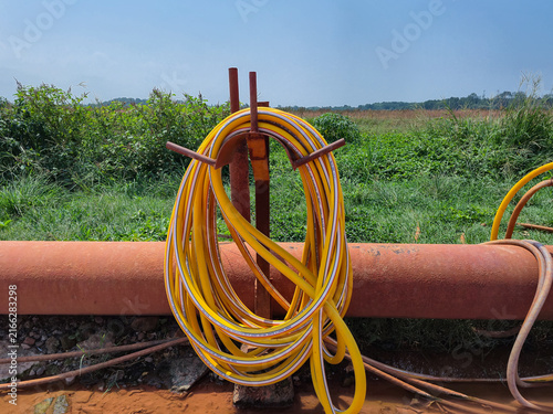 Cuadro en lienzo Yellow high pressure water hose coiled on stand at outdoor industrial and agricu