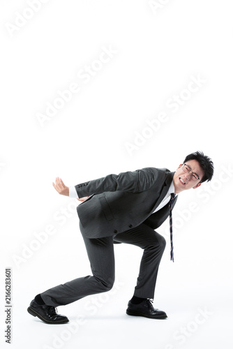 Stressed businessman crouching under pressure on white background