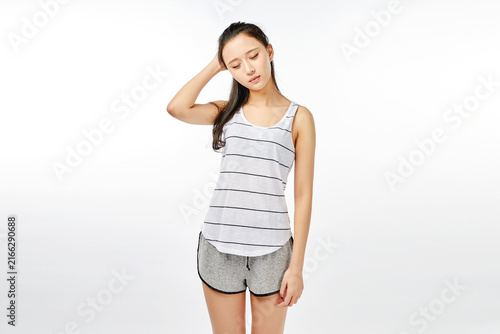 Obraz na plátne Tired young woman standing with hand on head in casual homewear