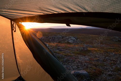 Tent on a little hill in northern Finland during sunset