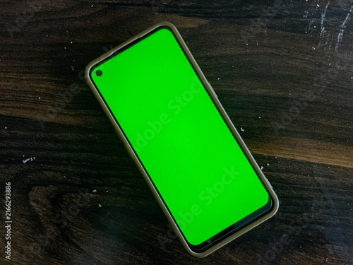 Fotografie Smartphone rests on dark wood surface