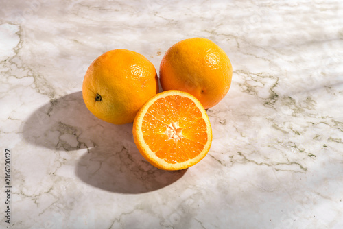 Canvas Print Freshly squeezed orange juice in a tall glass with straw and slice surrounded by