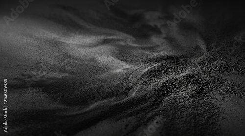 Graphite powder texture background. Dark abstract dust particles in motion.