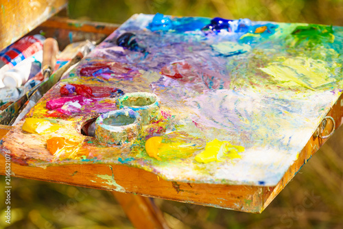 Bright palette filled with colors ready for painting outdoor scenery on a sunny day