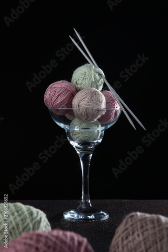 Obraz na plátně Creative still life: martini glass filled with balls of natural wool in pastel t
