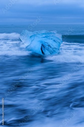 Ice floes lying on a black beach near Jokulsarlon glacier lagoon in Iceland