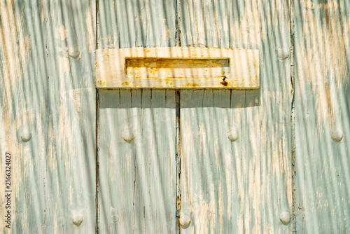 Wooden door with old rusty postbox