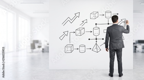 Businessman drawing flowchart on whiteboard, strategic planning, corporate management diagram with arrows and shapes, data analysis workflow visualization, team leadership meeting