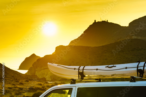 Canoe on top roof of car at sunset