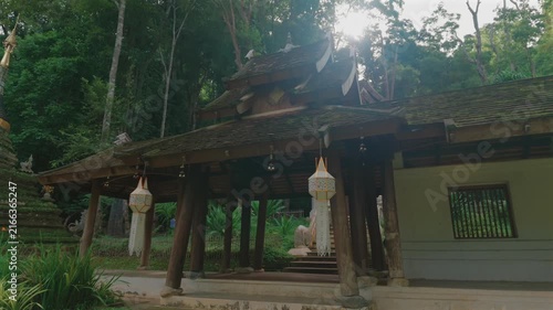 Entrance to Wat Phra Lat Buddhist temple by tropical forest in Chiang Mai Thailand, Traditional monastery architecture with peaceful garden courtyard and lush greenery at sunset 4k