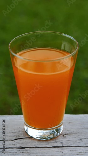 Fresh orange juice in a glass under natural sunlight