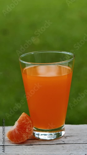 Fresh orange juice in a glass under natural sunlight