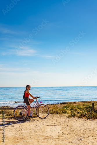 Woman ride bicycle on beach, active lifestyle.