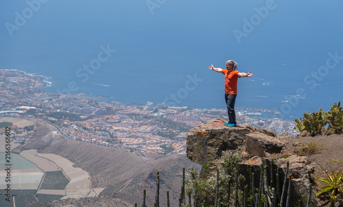 Man with arms open on a cliff