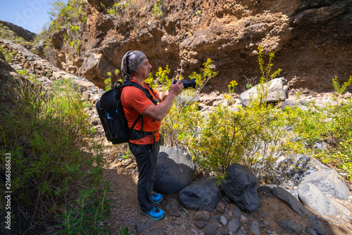 Hiker photographing a volcanic ravine