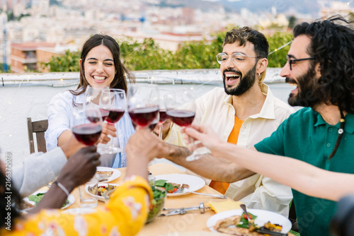 Принти на полотні Diverse friends enjoying a celebratory barbecue gathering on a building terrace,