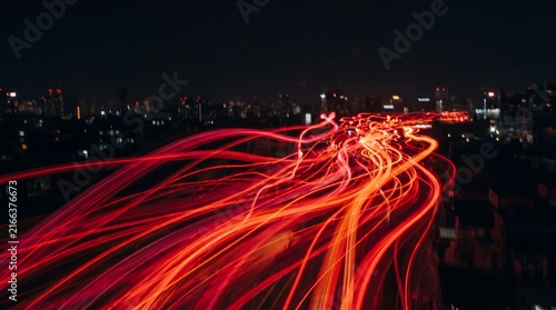 Abstract Red Light Trails Streaking Across a Dark Background, Representing Speed and Energy