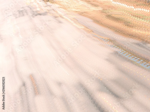 Abstract long exposure motion blur with sweeping diagonal lines on a pale textured surface and faint dotted trails