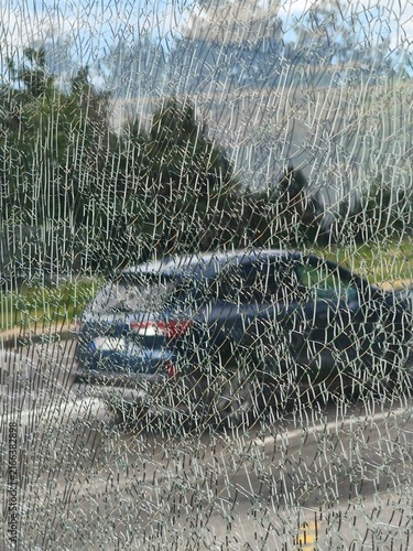Quadro su tela Close-up of shattered tempered safety glass texture with a blurred car and trees