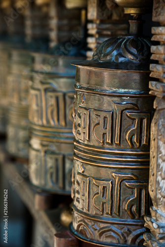 Canvas Print Ornate Tibetan Buddhist prayer wheels with embossed script and decorative metalwork, photographed in Vienna with shallow depth of field and warm, atmospheric lighting