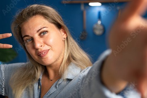 Foto Happy beautiful young woman taking a selfie portrait in a cozy home interior