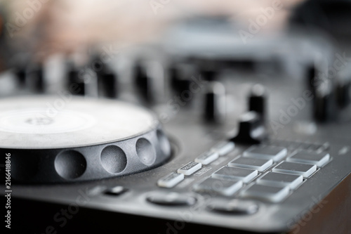 Fotografie Close-up of a modern black DJ controller with a jog wheel, performance pads, and